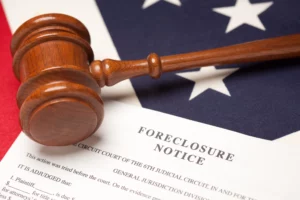 Wooden judge’s gavel resting on a foreclosure notice placed over a U.S. flag, symbolizing legal authority, property foreclosure proceedings, and Denver foreclosure prevention options.