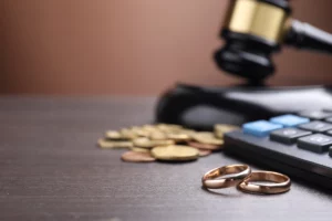 Wedding rings, coins, calculator, and gavel representing bankruptcy and divorce in Denver, Colorado